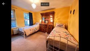 1 dormitorio con 2 camas y vestidor en Asdee House en Bushmills