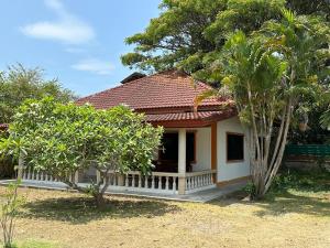 a small house with a red roof and some trees at Samui Garden Resort in Bang Rak Beach