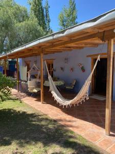 eine Veranda mit Hängematte auf einem Haus in der Unterkunft El Rancho Azul, casona antigua con piscina in Ciudad Lujan de Cuyo