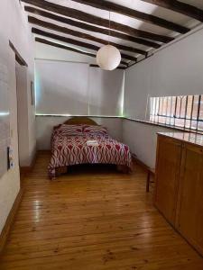 ein Schlafzimmer mit einem Bett in der Zimmerecke in der Unterkunft El Rancho Azul, casona antigua con piscina in Ciudad Lujan de Cuyo