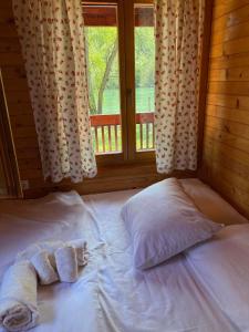 ein Bett mit Handtüchern in einem Zimmer mit Fenster in der Unterkunft Drinka in Ljubovija