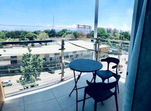 a balcony with a table and two chairs and a window at Condo at Primavera city next to SM Mall in Cagayan de Oro