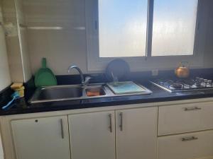 a kitchen counter with a sink and a stove at Studio au bord de la corniche in Rabat