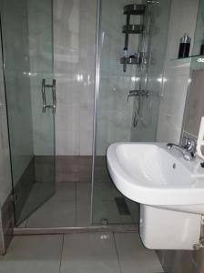 a bathroom with a glass shower and a sink at Studio au bord de la corniche in Rabat