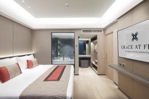 a bedroom with a bed and a sign that reads garage art hotel at Grace At Five by Grace Hotel Bangkok in Bangkok