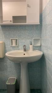 a white sink in a blue tiled bathroom at La dimora nonna Eugy in Polignano a Mare
