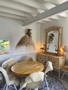 comedor con mesa de madera y sillas en Gîte Le Chat Chez Qui J'habite, en Saint-Aubin-sur-Mer