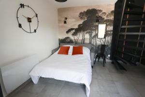 - une chambre avec un lit et une horloge murale dans l'établissement Maison la Cassine - Centre Doué la Fontaine - Proche Zoo, à Doué-la-Fontaine