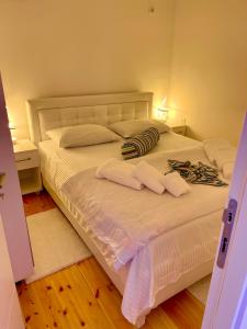 a white bed with two pillows and towels on it at Apartment Soreja in Ulcinj