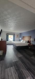1 dormitorio grande con 1 cama grande y ventana en Royal Inn & Suites, en Akron