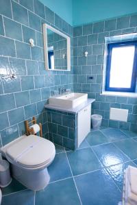 uma casa de banho em azulejos azuis com um WC e um lavatório em Casina Lambis em Pozzuoli