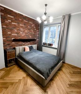 een slaapkamer met een bakstenen muur en een bed bij Apartament Jodełka na Powiślu in Warschau