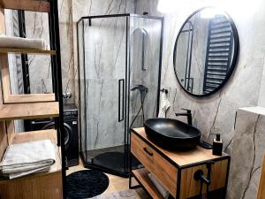 ein Bad mit einer Glasdusche und einem Waschbecken in der Unterkunft Apartament Jodełka na Powiślu in Warschau