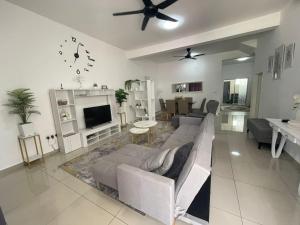 a living room with a couch and a tv at Safiyya Homestay in Kluang