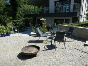 a patio with chairs and a table in front of a building at FeWo-Seefunkeln in Diensdorf am Scharmützelsee in Diensdorf-Radlow
