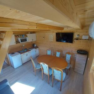 eine Küche mit einem Tisch und Stühlen in einer Hütte in der Unterkunft Brunarica Jeršin in Cerkno