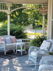 a porch with white wicker chairs and a pergola at Grand Victorian B&B Inn in Bellaire