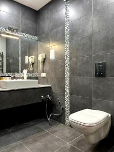 ein Badezimmer mit einem WC, einem Waschbecken und einer Badewanne in der Unterkunft Marmenio Hotel - Tbilisi in Tbilisi City