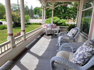 a porch with blue and white chairs and a table at Grand Victorian B&B Inn in Bellaire
