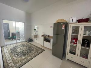 a kitchen with a stainless steel refrigerator and a rug at Safiyya Homestay in Kluang