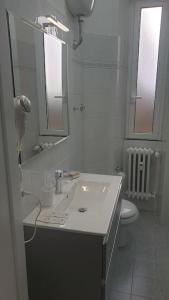 a white bathroom with a sink and a toilet at Delizioso appartamento San Pietro in Rome