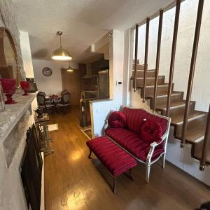 uma sala de estar com um sofá vermelho e escadas em GorkyHouseUrla em Ildır