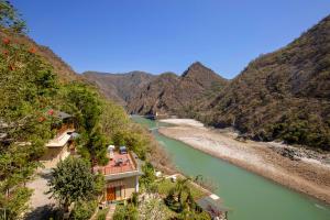 a view of a river with mountains in the background at Raga on the Ganges, Rishikesh in Rishīkesh