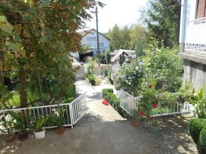 einen Garten mit Topfpflanzen und einem weißen Zaun in der Unterkunft Villa Ljubica 