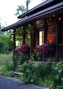 una cabaña de madera con flores delante en Villa Leonore: Sommerhus m/strandlinje på Helgøya en Ringsaker