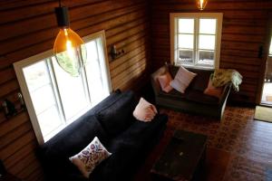 a living room with a black couch and a window at Villa Leonore: Sommerhus m/strandlinje på Helgøya in Ringsaker