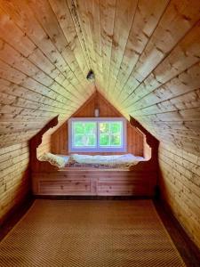 een kleine kamer met een raam in een houten huis bij Villa Leonore: Sommerhus m/strandlinje på Helgøya in Ringsaker