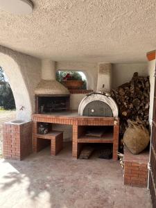 un horno de piedra con una pila de leña en Villa Clementina - Sant'Antioco en SantʼAntìoco