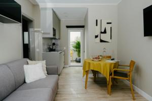 - un salon avec un canapé gris et une table jaune dans l'établissement Casa dos Limos - Apartments, à Foz do Arelho