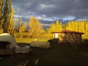 a small building in the middle of a field with trees at Buda de Uco Lodge in Tunuyán