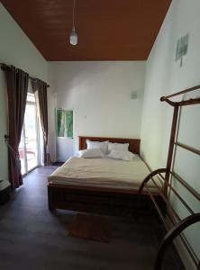 1 dormitorio con cama y ventana grande en Sarah Holiday Resort, en Haldummulla