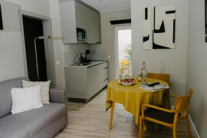 Una pequeña sala de estar con una mesa y un sofá. en Casa dos Limos - Apartments, en Foz do Arelho 26 fotos más