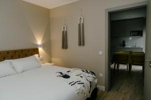 Cet appartement comprend une chambre avec un lit et une table ainsi qu'une cuisine. dans l'établissement Casa dos Limos - Apartments, à Foz do Arelho