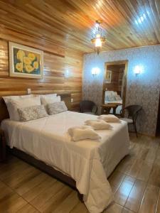 a bedroom with a large white bed in a room at Cabanas Por do Sol in Urubici