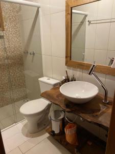 a bathroom with a sink and a toilet and a mirror at Cabanas Por do Sol in Urubici