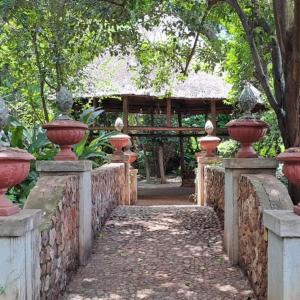 a stone fence with vases on it with a gate at Duck and Dine in Pretoria