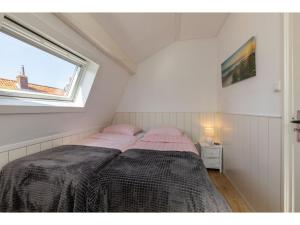 een slaapkamer met een bed in een kamer met een raam bij Lovely holiday home near center of Domburg in Domburg