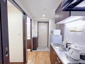 a kitchen with a sink and a refrigerator at shizuka1 401 in Osaka