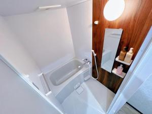 a small bathroom with a tub and a sink at shizuka1 401 in Osaka