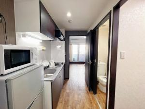 a small kitchen with a sink and a microwave at shizuka1 401 in Osaka