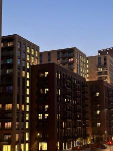 um grupo de edifícios altos em uma cidade à noite em Lovely Stay near Central London em Londres