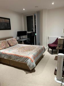 um quarto com uma cama, uma mesa e cadeiras em Lovely Stay near Central London em Londres