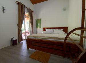 1 dormitorio con 1 cama con marco de madera en Sarah Holiday Resort, en Haldummulla