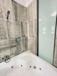 uma banheira na casa de banho com um chuveiro em vidro em Stay In Carlazo - Unlimited WiFi, Solar backup em Roodepoort