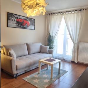 a living room with a couch and a table at Apartament Centrum Park in Olsztyn
