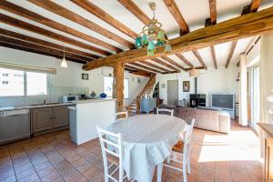 cocina y comedor con mesa y sillas en Les Hortensias à 50 m de la plage de Trestraou en Perros-Guirec